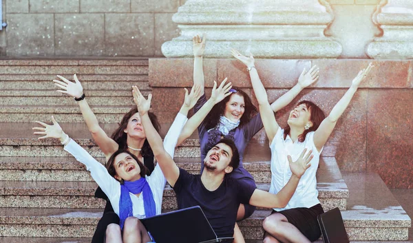 Eine Gruppe fröhlicher Schüler hebt bei sonnigem Wetter freudig die Hände — Stockfoto