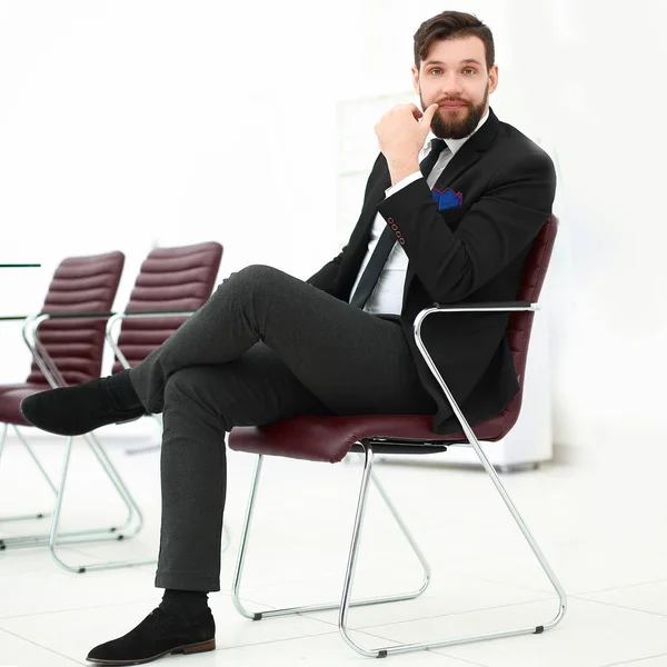 Schöner Geschäftsmann sitzt auf einem Stuhl in einem Konferenzraum — Stockfoto