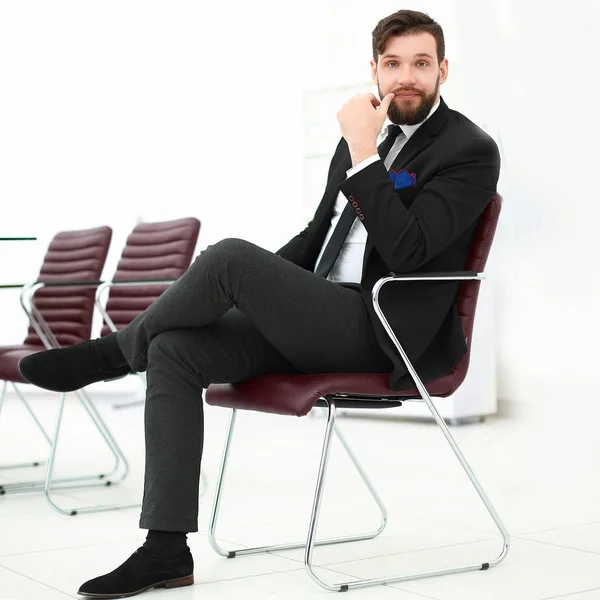 Handsome businessman sitting on a chair in a conference room — Stock Photo, Image