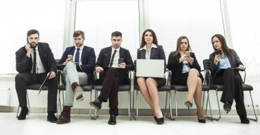 bir smartphone ve modern ofis lobisinde otururken dizüstü kullanarak internette bilgi arayan iş takım