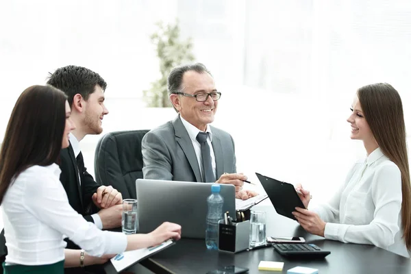 Gerente discutindo problemas de trabalho com seus assistentes atrás de uma mesa — Fotografia de Stock