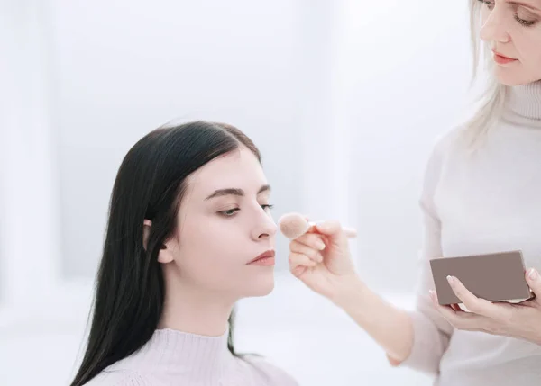 Maquillar artista haciendo profesional maquillaje de mujer joven —  Fotos de Stock