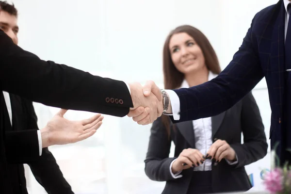 Zavřete up.handshake obchodních partnerů v pozadí úřadu — Stock fotografie