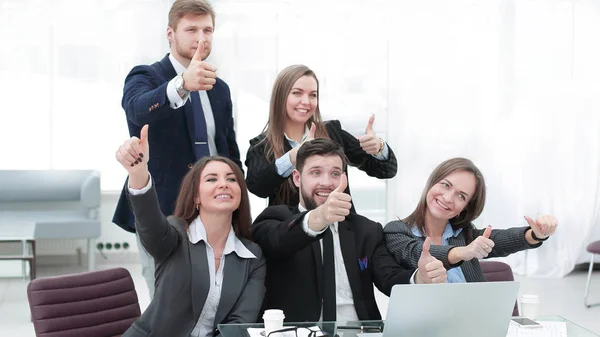 Бізнес-команда з великими пальцями вгору і голосувати за рішення біля стільниці — стокове фото