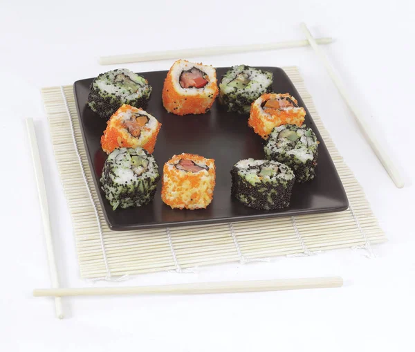 Diferentes tipos de sushi Maki em uma placa preta — Fotografia de Stock