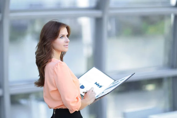 Eine junge Geschäftsfrau hält einen Ordner mit Finanzdokumenten in der Hand. — Stockfoto