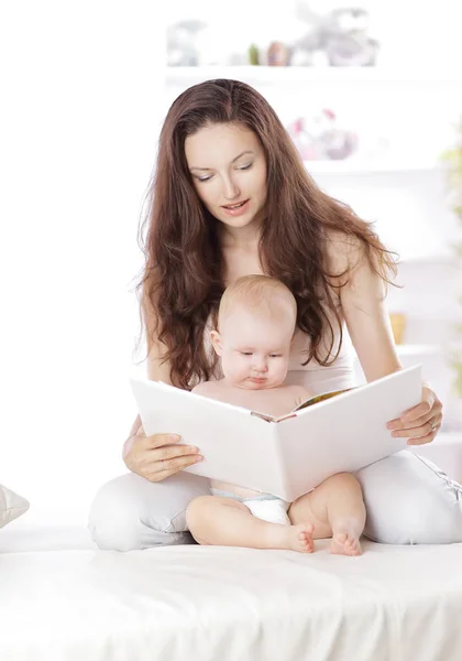 Młoda matka czyta książkę swojej córeczce — Zdjęcie stockowe