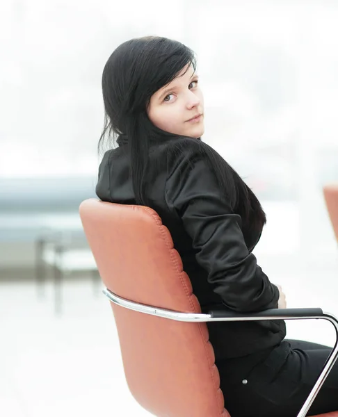 Yan view.young iş kadını ofis koltuğunda oturmak — Stok fotoğraf