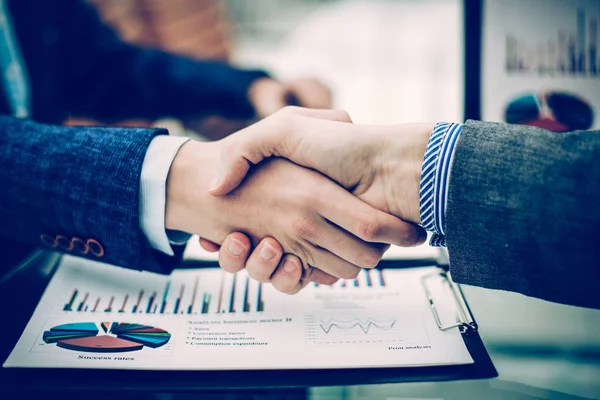 Handshake finansiella partner på bakgrunden av arbetsplatsen — Stockfoto