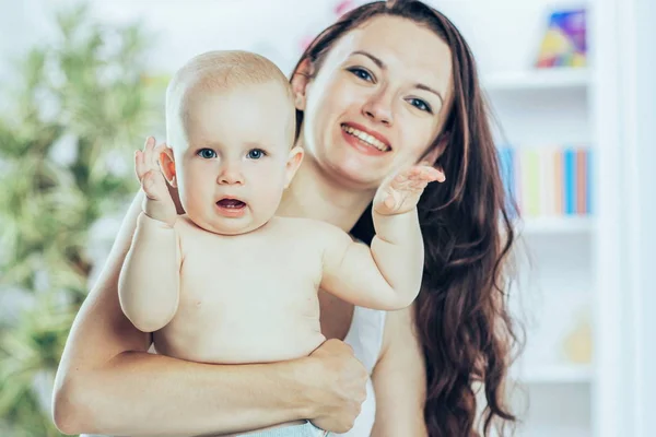 Retrato de mamá feliz con un niño de un año en el fondo de una habitación de niños — Foto de Stock