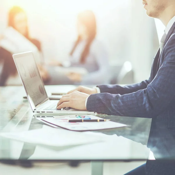 Gestionnaires financiers travaillant sur ordinateur portable avec des données financières sur le lieu de travail dans un bureau moderne — Photo