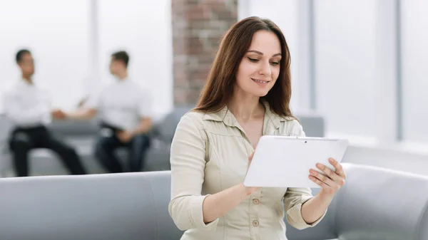 Mujer de negocios con tableta digital sentado en el sofá en el vestíbulo de la oficina — Foto de Stock