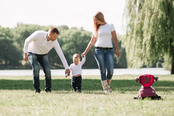 Matka, otec a hrát si s jejich malého syna na procházku v letním parku. — Stock fotografie