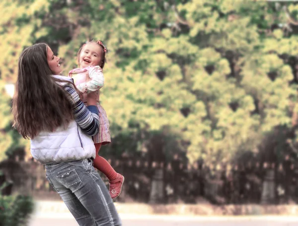 Lächelnde Mutter und kleine Tochter über die Natur. glückliche Menschen im Freien — Stockfoto