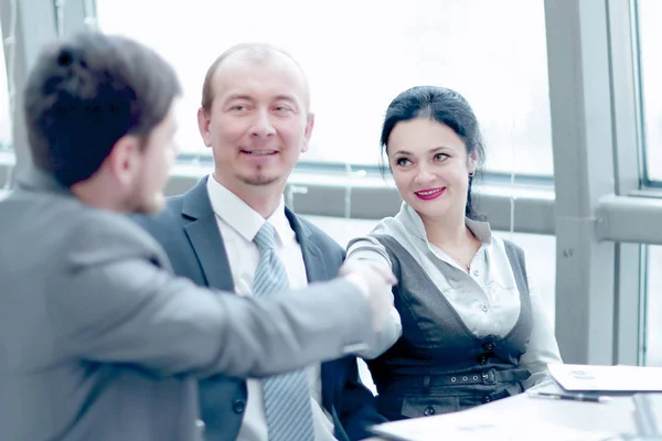 Líderes de negocios femeninos y masculinos sonrientes apretones de manos sobre el escritorio —  Fotos de Stock