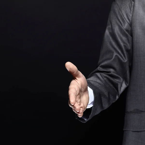 Close up.businessman, mão para fora para um handshake.isolated no fundo preto — Fotografia de Stock