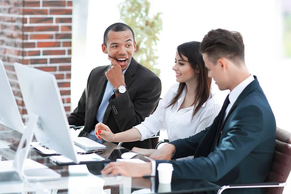 Professional business team talking while sitting behind a Desk — Stock Photo, Image