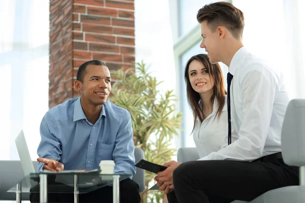 Business-team tittar på laptop skärmen, sitter bakom ett skrivbord — Stockfoto