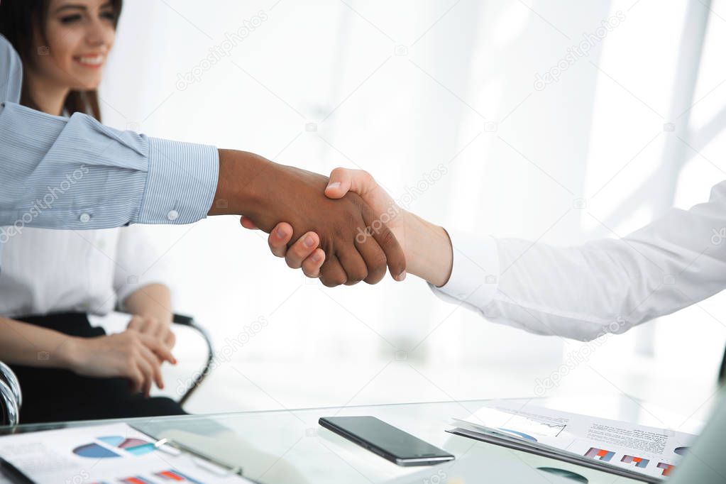 closeup.the financial partners shaking hands over a Desk.