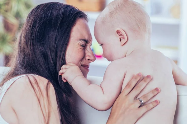 Conceito de maternidade: mãe feliz brincando com um bebê de um ano no quarto para crianças — Fotografia de Stock