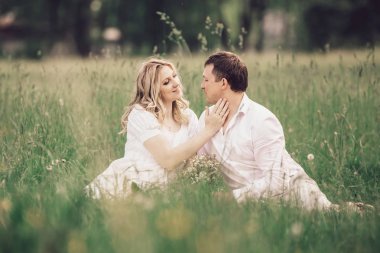 güzel çift çimen bir yaz parkta oturan