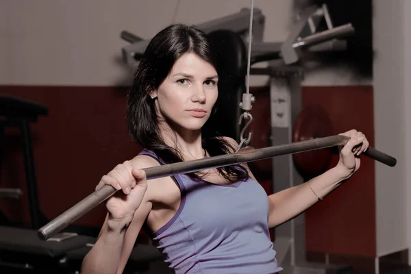 Sporty woman sitting on the floor in the fitness center — Stock Photo, Image