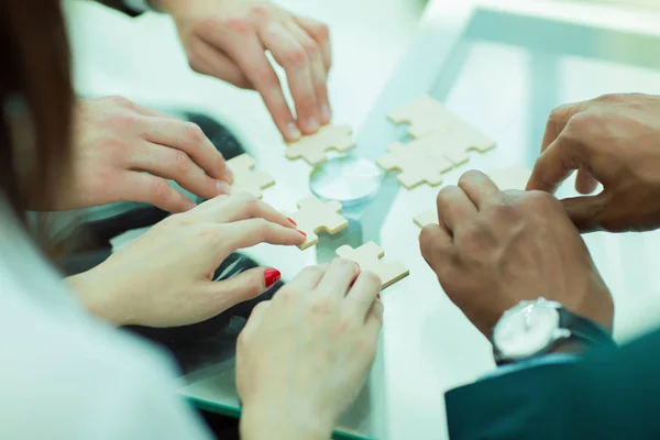 De cerca. equipo de negocios ensamblando piezas de rompecabezas . — Foto de Stock