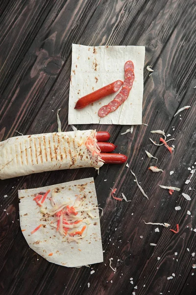 Salsicce di cottura in pane pita.ingredienti sul tavolo di legno — Foto Stock