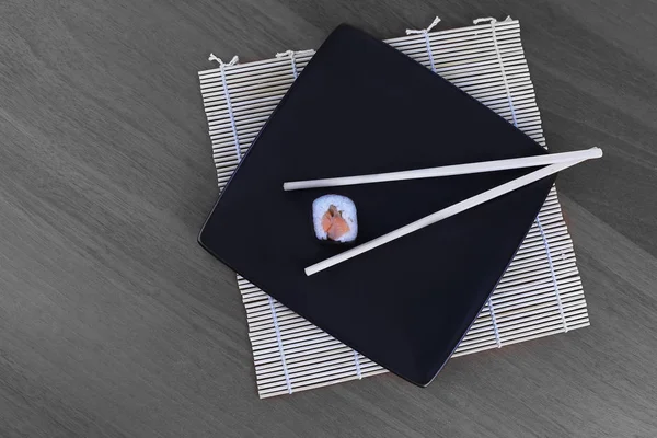Närbild av sushi och ätpinnar på ett träbord — Stockfoto
