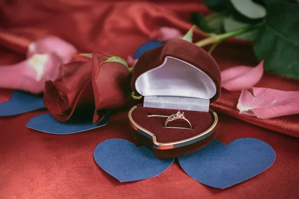 Anel com um diamante sobre um fundo vermelho — Fotografia de Stock