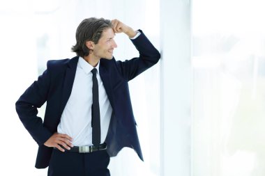 office penceresinde yakın duran gülümseyen iş adamı