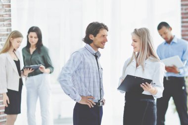 modern bir ofiste duran iş adamı ve iş kadın.
