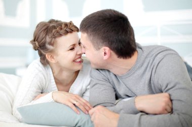 Genç, gülümseyen romantik çift birbirinin yanında rahatlıyor..