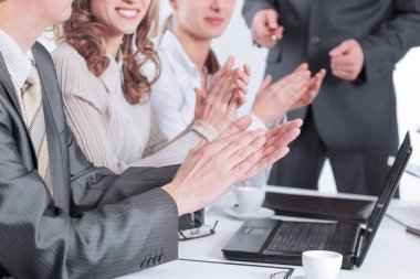 bir masanın arkasında oturan applauding iş takım
