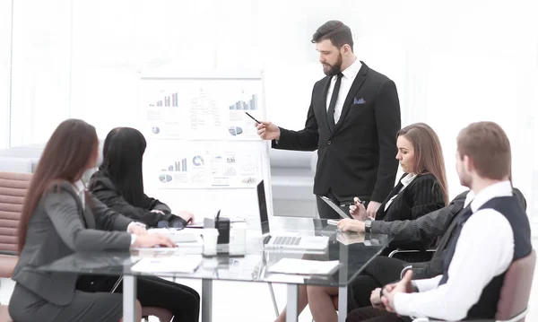 Attente zakenpartners kijken naar succesvolle ondernemer wijzend op het whiteboard in kantoor — Stockfoto