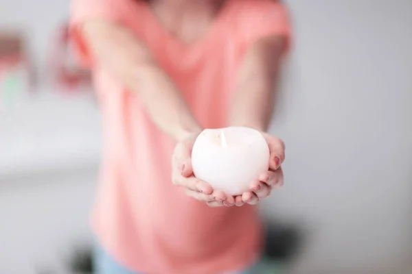 Sluit up.a mooie jonge vrouw breidt een brandende kaars — Stockfoto