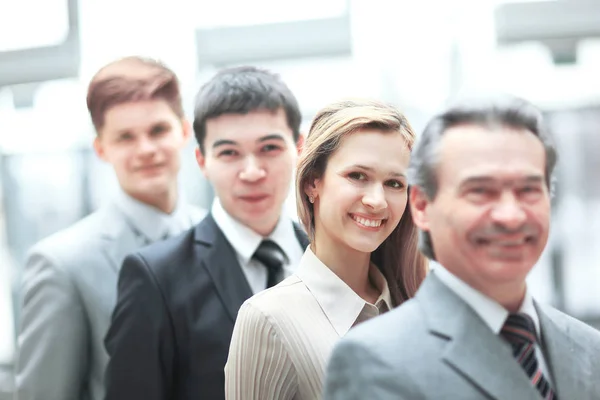 Uomo d'affari in piedi di fronte al suo team di lavoro su sfondo ufficio offuscata — Foto Stock