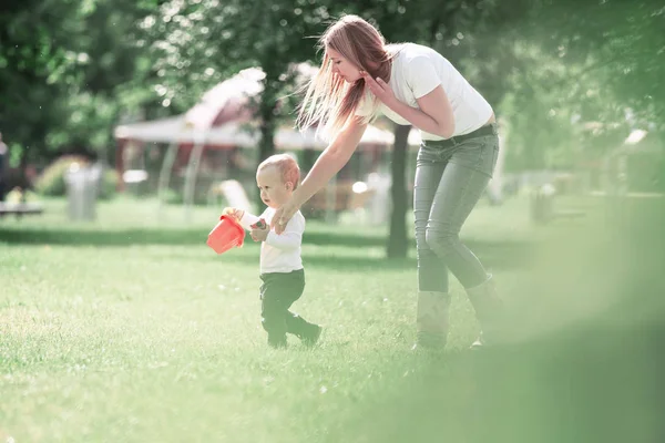 Mami y su pequeño hijo en un paseo por el parque de la ciudad . —  Fotos de Stock