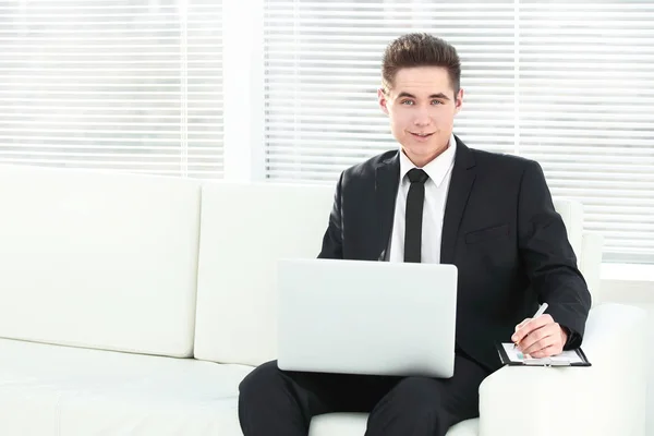 Homme d'affaires confiant travaillant sur ordinateur portable assis dans le bureau spacieux — Photo