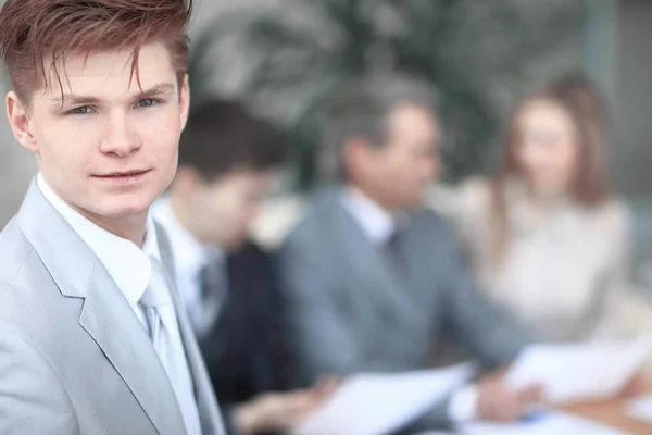 Close up.the visage d'un jeune homme d'affaires sérieux sur fond flou bureau — Photo