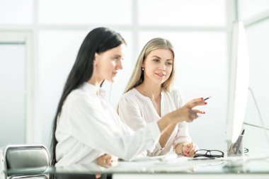 iki çalışanı office masada oturan bir şey görüşüyorlar