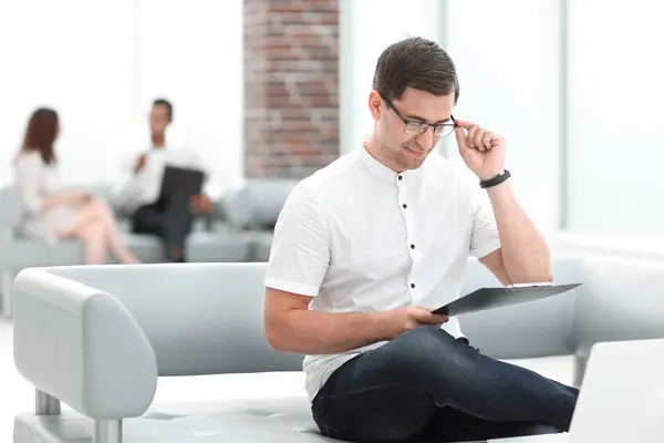 Businessman working with documents, sitting in the lobby of the business center — Stock Photo, Image