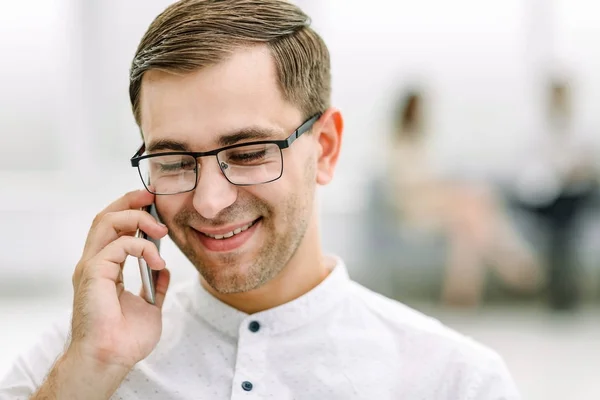 Close up. smiling businessman talking on his smartphone — стоковое фото