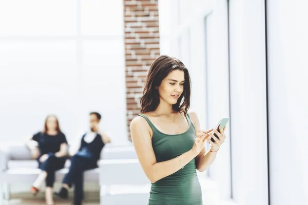 Ung kvinne som skriver SMS på smarttelefonen sin – stockfoto