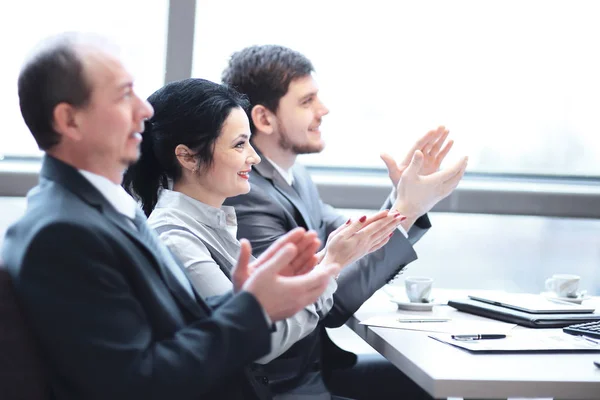 Close up.business équipe applaudissant le conférencier, assis sur le lieu de travail . — Photo