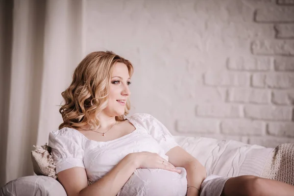 Zblízka. Mladá těhotná žena leží na gauči — Stock fotografie