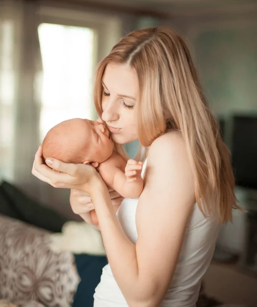 Szczęśliwa mama z noworodka stoi w pokoju. — Zdjęcie stockowe