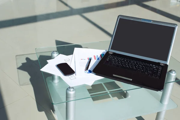 Laptop aberto e telefone celular no desktop do escritório — Fotografia de Stock