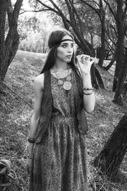 Genç hippi kadın şehir parkında yürüyüş yapıyor. siyah beyaz fotoğraf