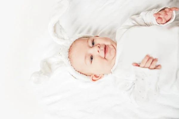 Gros plan. joli bébé en costume de lapin couché sur le lit . — Photo
